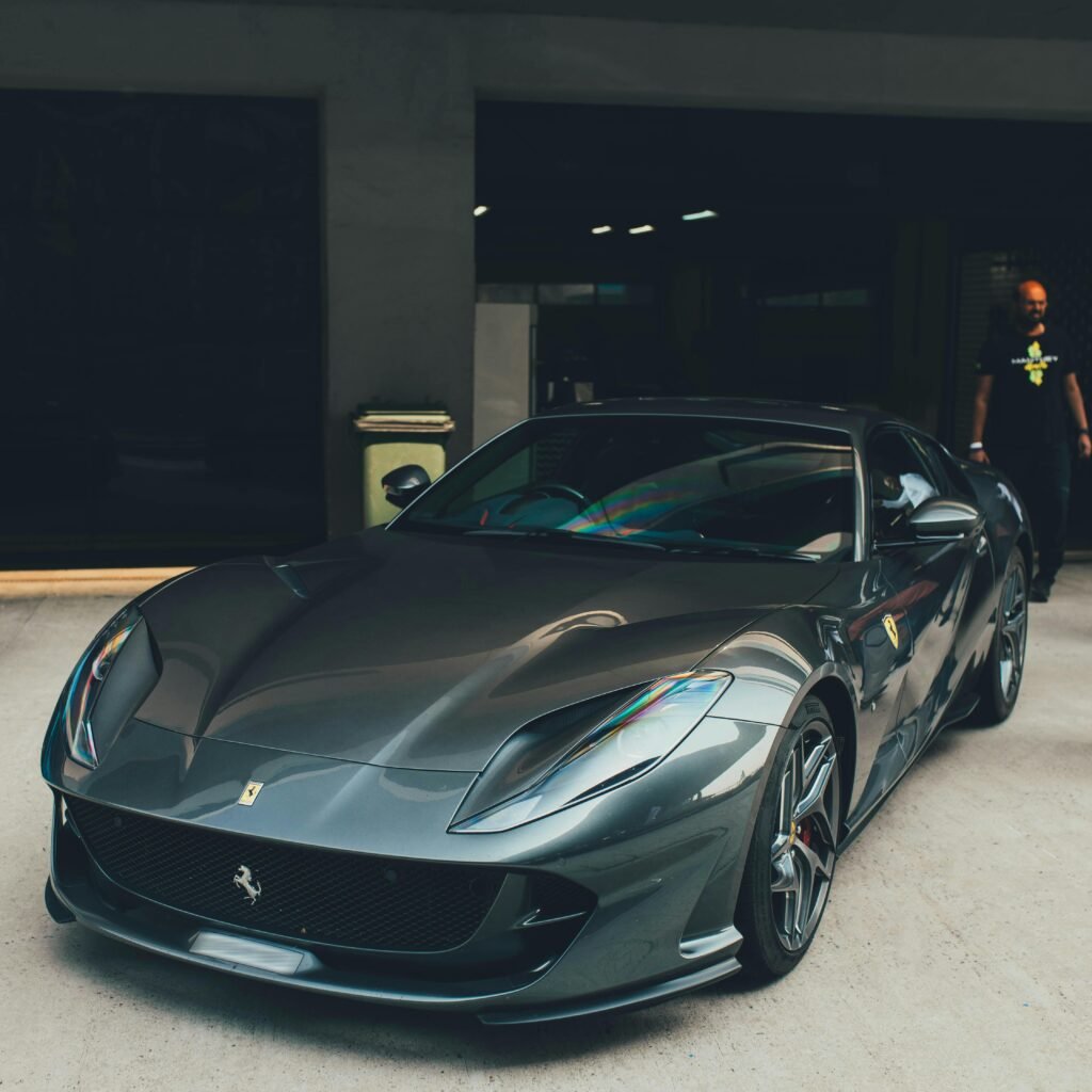 A sleek grey Ferrari supercar is showcased outdoors in Noida, India, capturing luxury automotive excellence.